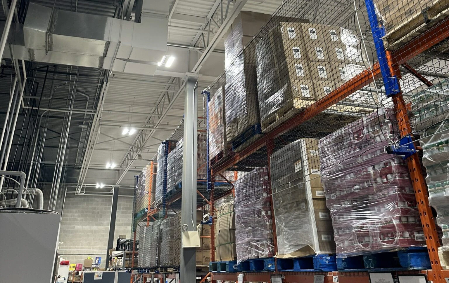 Fluorescent lights above warehouse shelving.